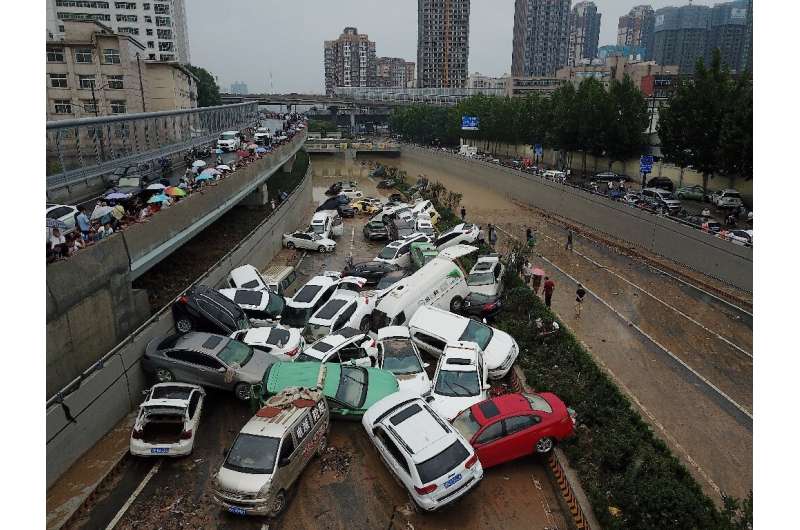Piles of cars swept away by floods lie at the entrance to a tunnel in Zhengzhou