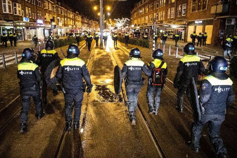 Police officers patrol the streets of Rotterdam a day after clashes with demonstrators protesting against new Covid-19 restricti