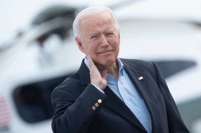President Joe Biden touches his neck after a cicada crawled up it on June 9, 2021