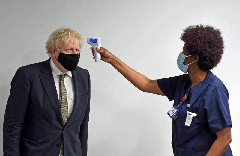 Prime Minister Boris Johnson has his temperature checked during a visit to Chase Farm Hospital in north London on Monday