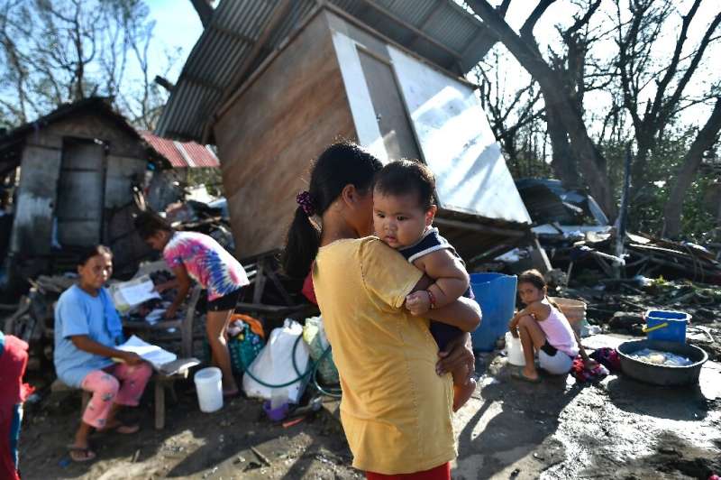 Residents take stock next to their destroyed house in Carcar, Cebu province