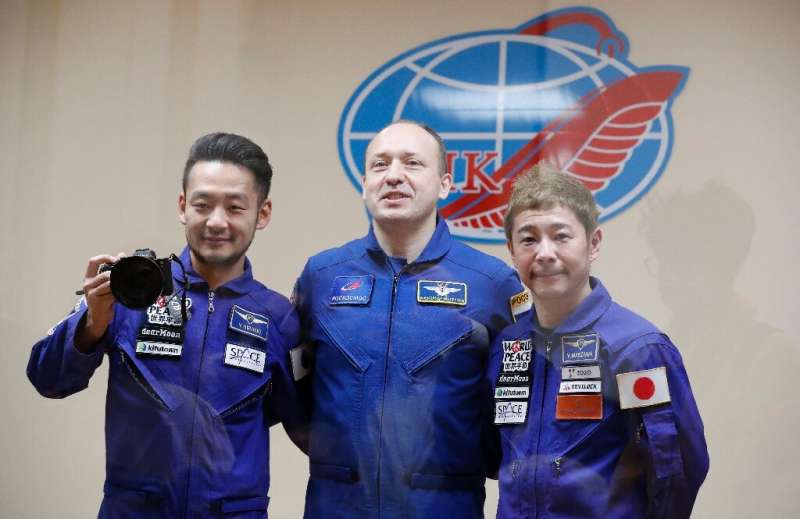 Russian cosmonaut Alexander Misurkin (C), Japanese billionaire Yusaku Maezawa (R) and his assistant Yozo Hirano will take part i