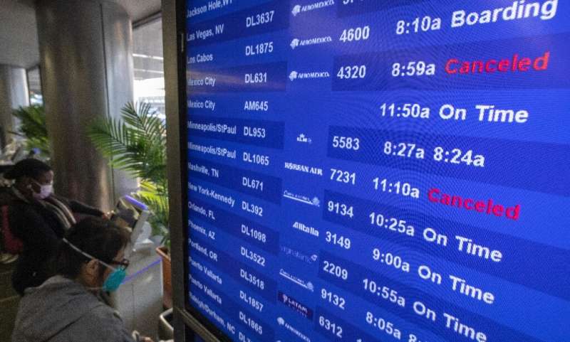 Travelers check flight information at Los Angeles International Airport