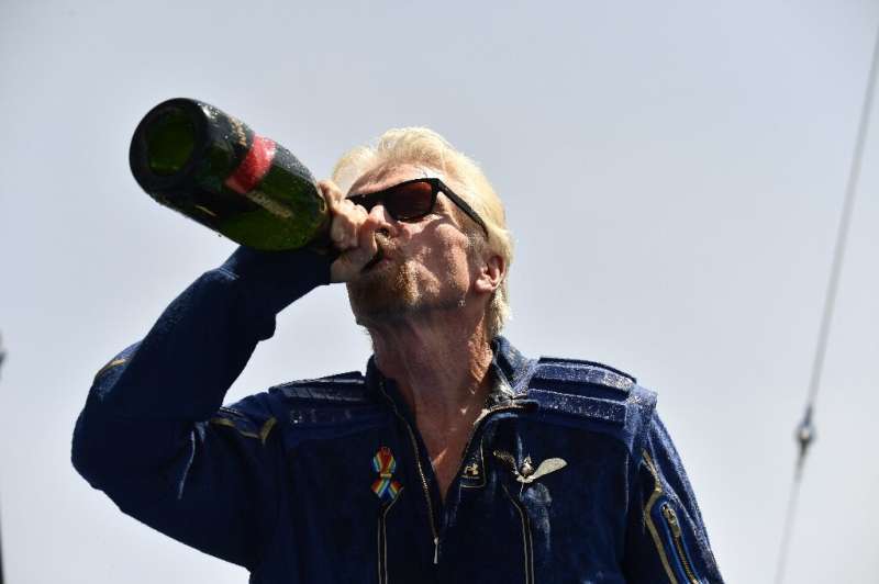 Virgin Galactic founder Richard Branson drinks champagne after his space flight