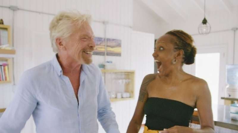 Virgin Galactic founder Richard Branson (L) surprises space travel sweepstakes winner Keisha Schahaff at her home on Antigua on 