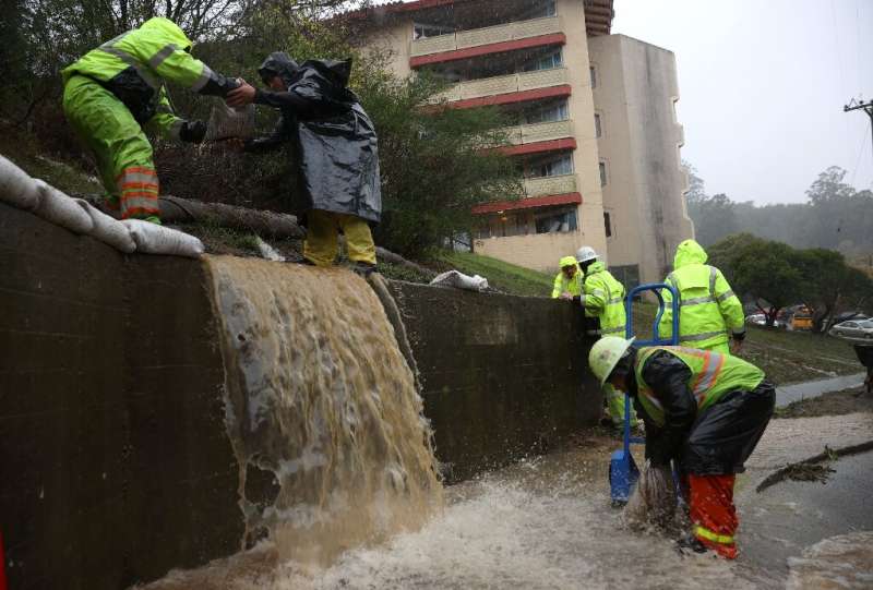 Workers try to divert water into drains in Marin City, California
