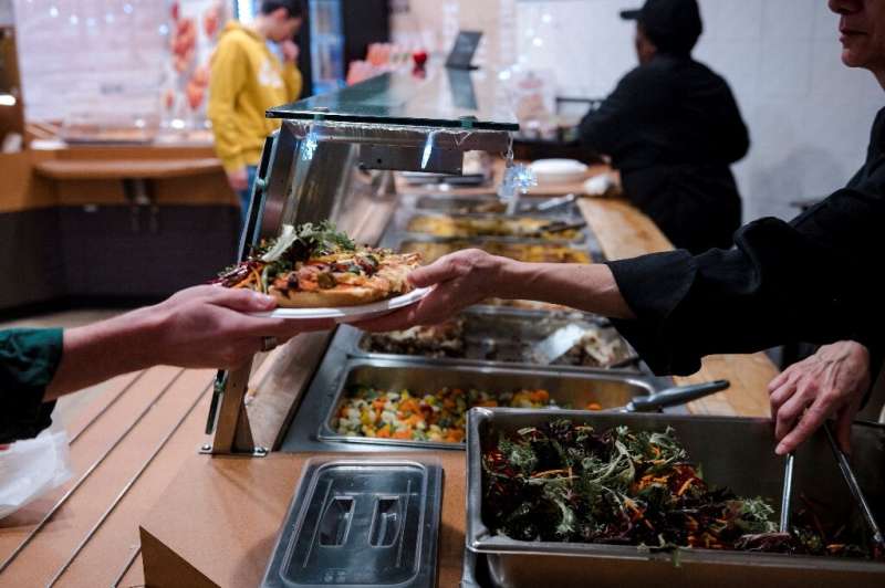A cafeteria employee hands food to a student at Polytechnique Montreal university on December 1, 2022
