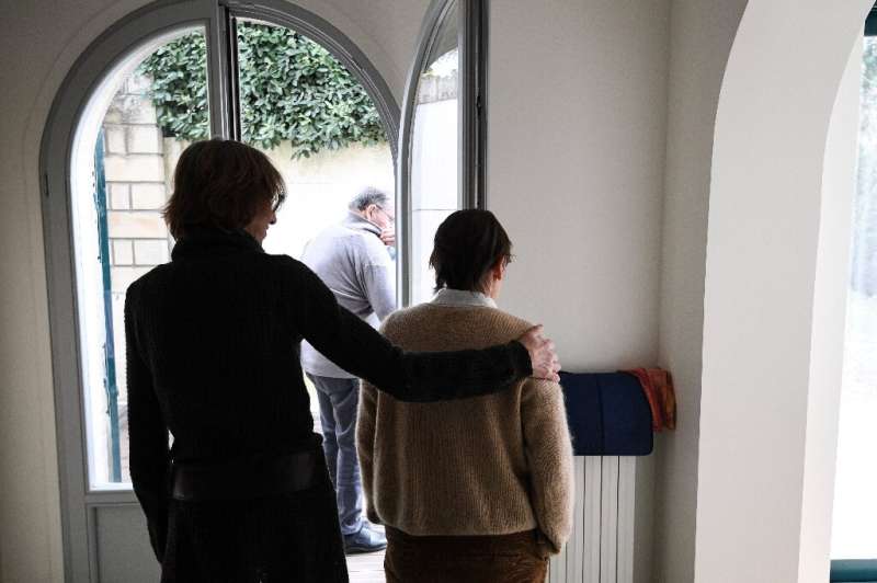 A carer helps an elderly resident - one of three alzheimer sufferers in the establishment- in a house at L'Hay-les- Roses on the
