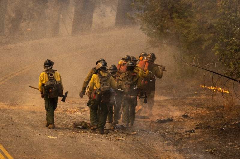 A crew marches to a new location to fight the Oak Fire near Midpines, northeast of Mariposa, California, on July 23, 2022
