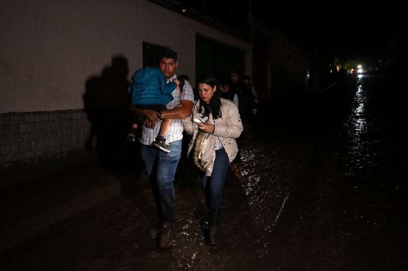 A family evacuates their home after a landslide in northern Venezuela that has left three dead