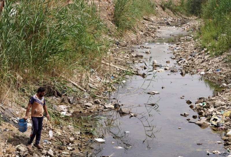 A farmer fetches water from a drying and polluted stream in Najaf province -- Iraq is classified as one of five most vulnerable 