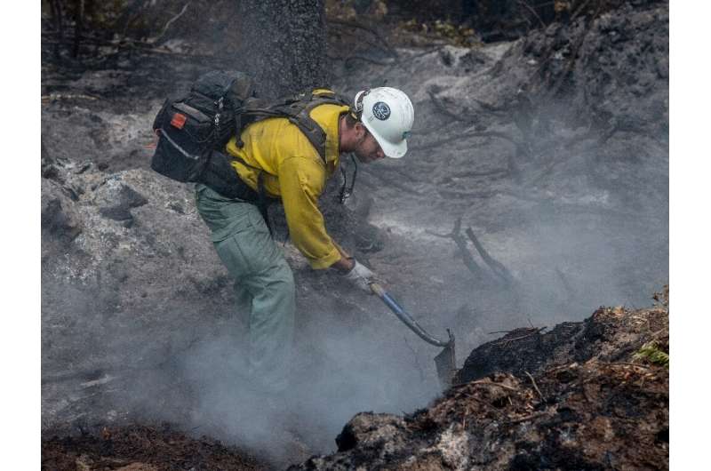 A firefighter works on a hotspot of the Cedar Creek fire just east of Oakridge, in the US state of Oregon