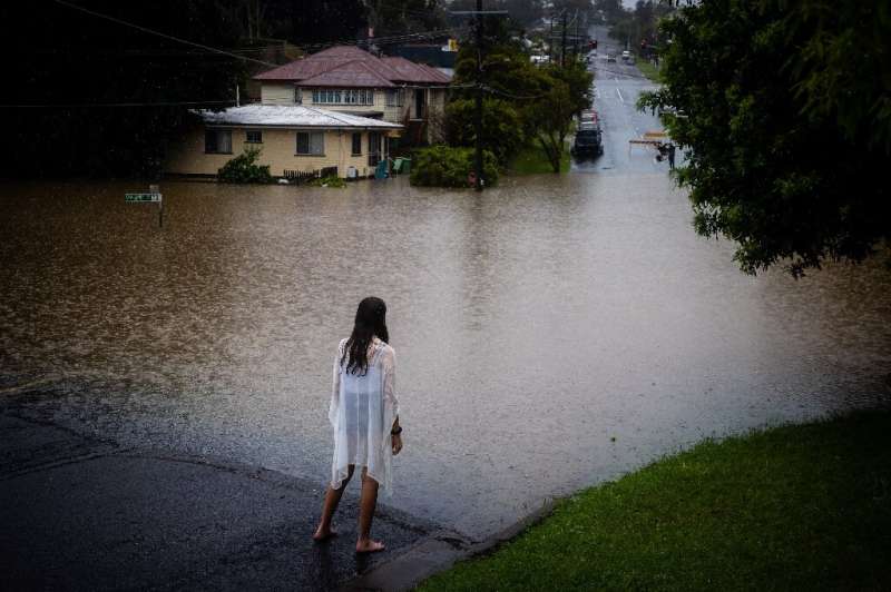 A girl looks at rising floodwaters of the Bremer river in West Ipswich, Queensland
