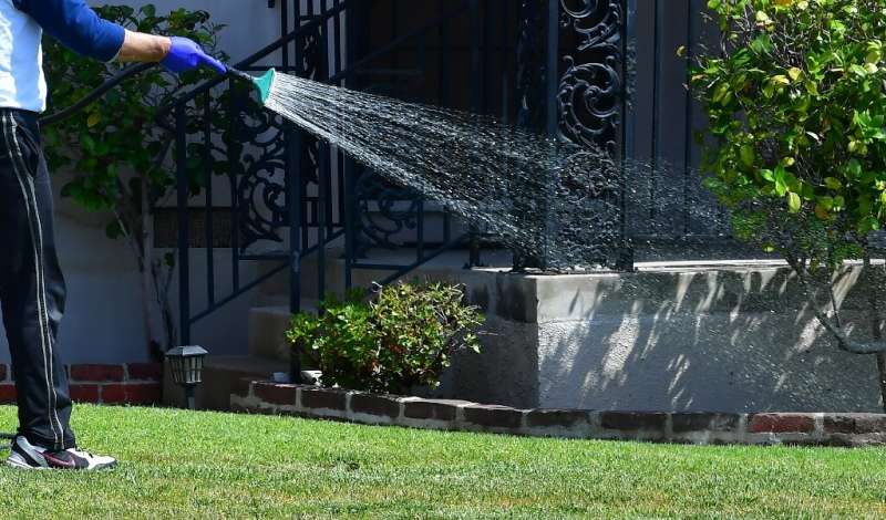 A man watering his lawn in  Alhambra, California, in April 2022