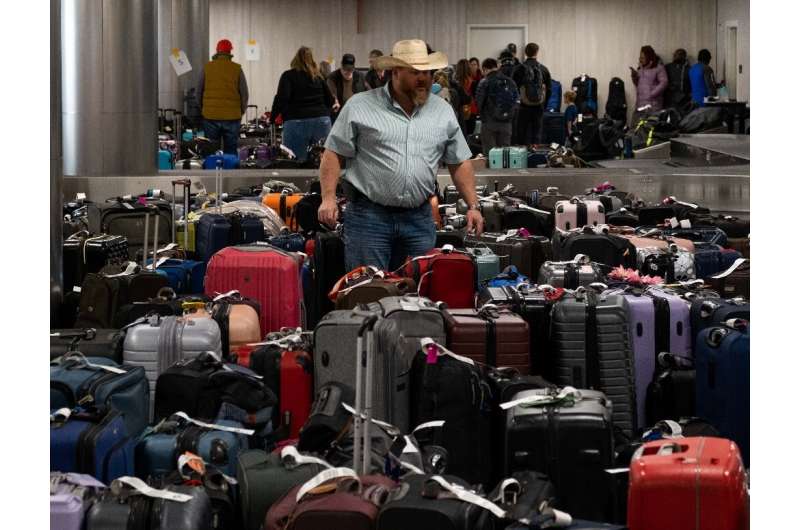 A passenger searches through hundreds of unclaimed suitcases near the Southwest Airlines baggage claim area at Nashville Interna
