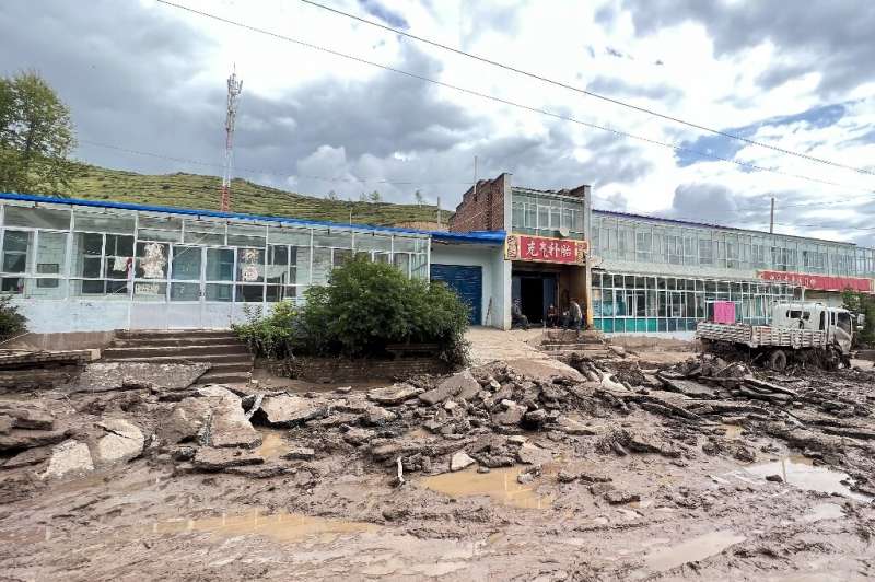A road is damaged after a flash flooding caused by a sudden downpour triggered mudslides in Datong county, Xining city, in China