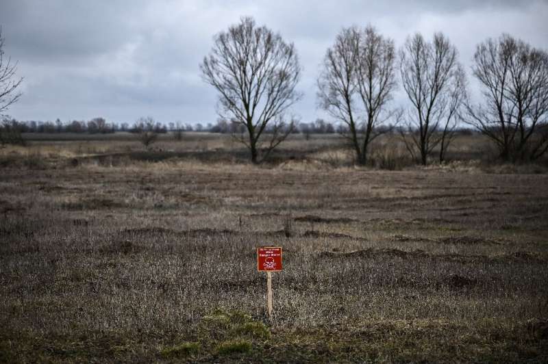 Un cartel que dice "peligro de minas" en un campo al noreste de la capital de Ucrania, Kiev, donde la población local normalmente cultiva trigo y otros c