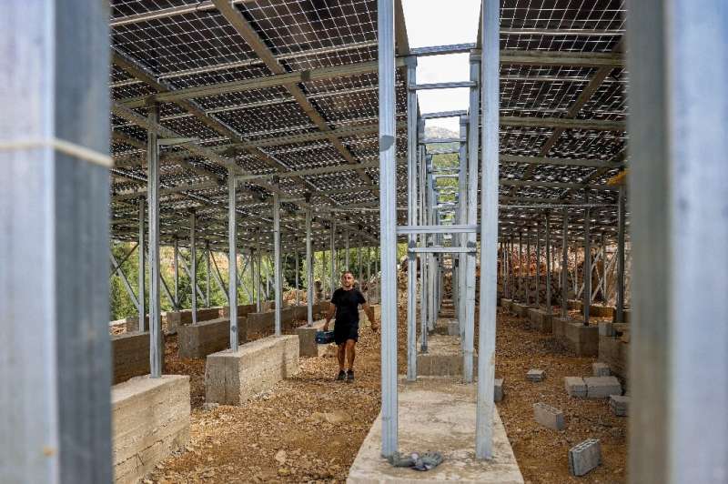 A technician works on the solar panel system installed for the village of Toula in northern Lebanon