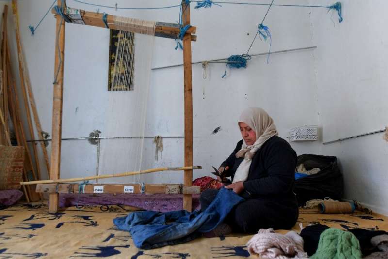A Tunisian craftswoman weaves a carpet from old fabric in the remote Nefta oasis