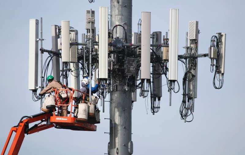 A Verizon crew updates a cell tower to handle the 5G network in Orem, Utah in December 2019