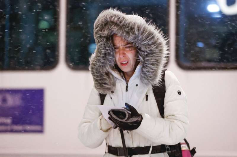 A woman braves freezing weather in Chicago as North America shivers in a historically cold storm