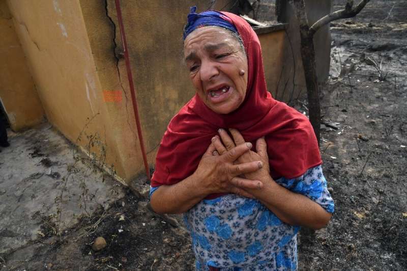 An Algerian woman in front of the ruins of her home, destroyed in a wildfire in the city of El Kala, on August 18, 2022