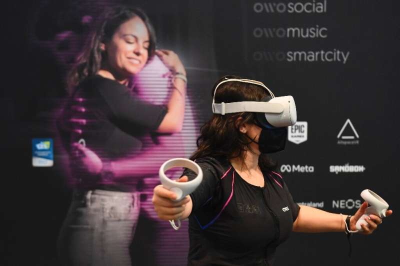 An attendee demonstrates the Owo vest, which allows users to feel physical sensations during virtual reality experiences includi
