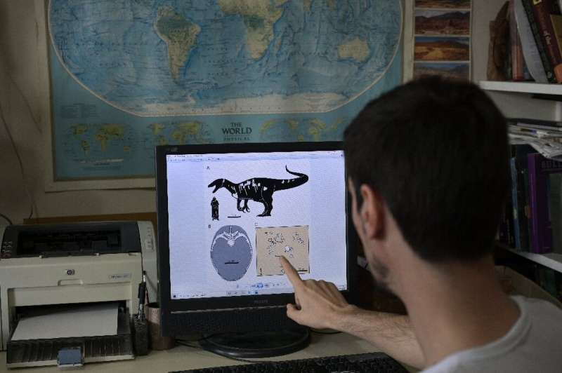 Argentine paleontologist Mauro Aranciaga with a graphic illustration of Maip macrothorax towering over a human