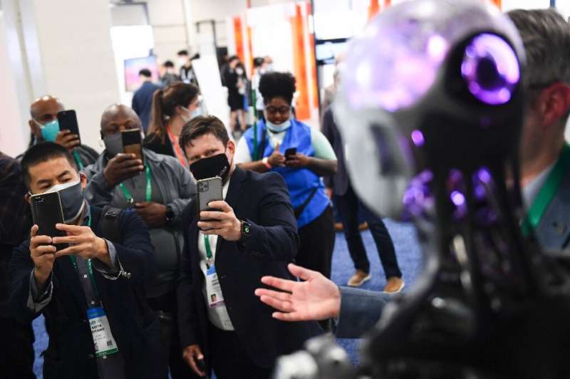 Attendees take pictures of the Engineered Arts Ameca humanoid robot with artificial intelligence is demonstrated during the Cons