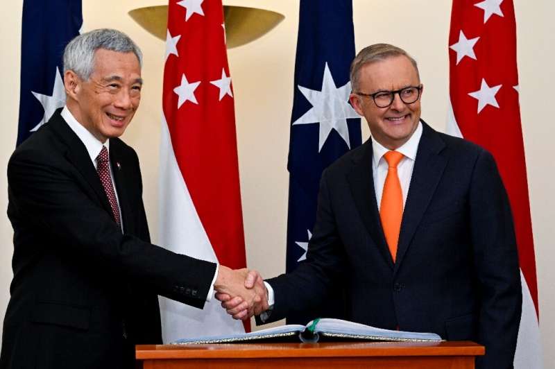 Australia's Prime Minister Anthony Albanese (R) shakes hands with Singapore's Prime Minister Lee Hsien Loong during their meetin