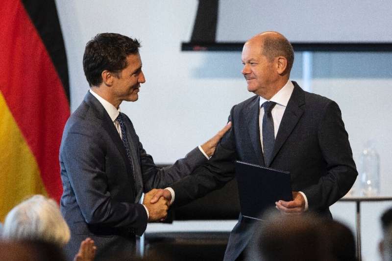Canada's Prime Minister Justin Trudeau (L) shakes hands with German Chancellor Olaf Scholz in Toronto, where the leaders agreed 