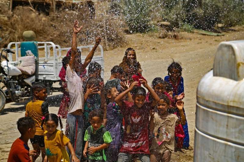 Children are sprayed with water when it is delivered to their village: Iraq is known in Arabic as the Land of the Two Rivers, bu