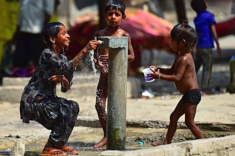 Children in Allahabad, India try to beat the heat as they bathe at a roadside tap on a scorching day