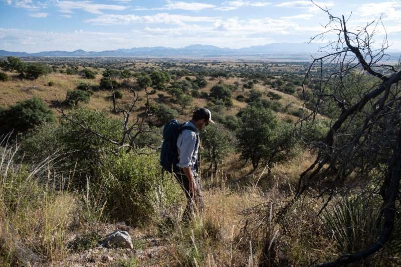 El guardia de seguridad Eamon Harrity camina cerca de la frontera entre Estados Unidos y México para recolectar imágenes de una cámara trampa
