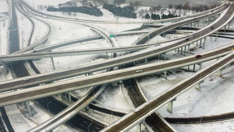 Водители едут по заснеженному шоссе в Луисвилле, штат Кентукки, которое пострадало от морозов 23 декабря 2020 года.
