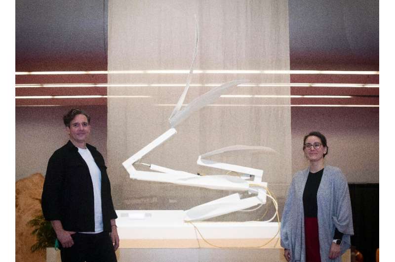 Dutch artist Thijs Biersteker (L) and scientist Adriana de Palma pose in front of "ECONARIO" an art installation by Bi