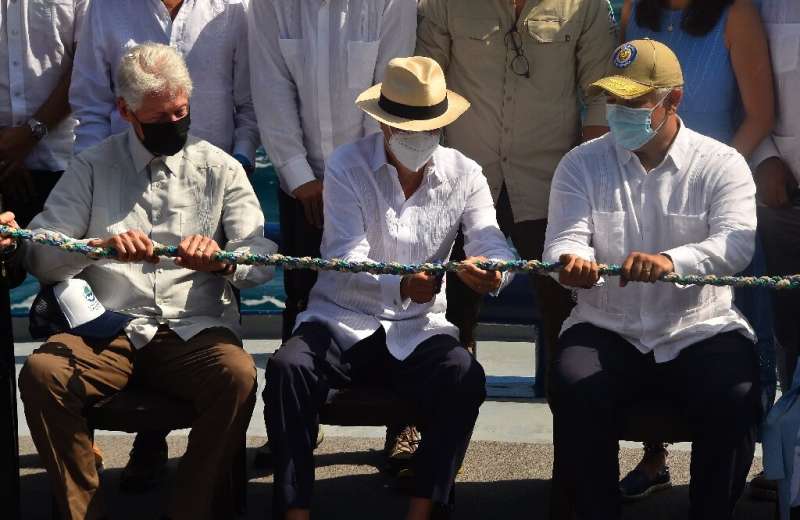 Ecuadorian President Guillermo Lasso (C) cuts ropes made of materials collected from coastal cleanups and is symbolically launched.