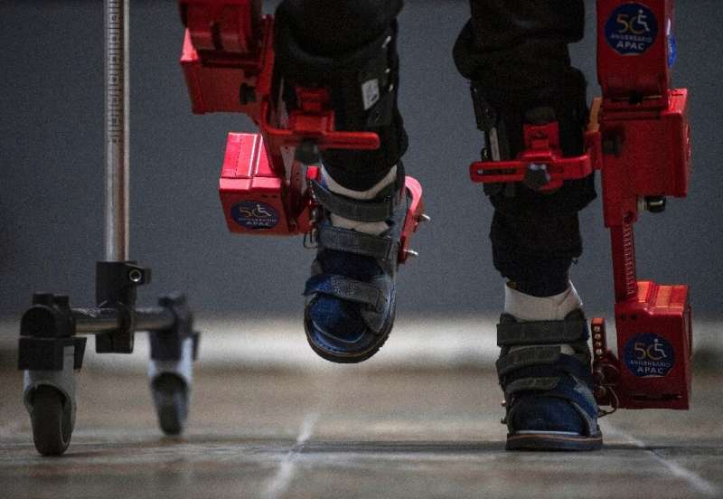 Eight-year-old David Zabala walks with the help of a robotic exoskeleton during a rehabilitation session in Mexico City