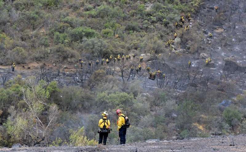 Firefighters were able to beat back a massive wildfire outside Los Angeles after a tropical storm brought rains and cooler tempe