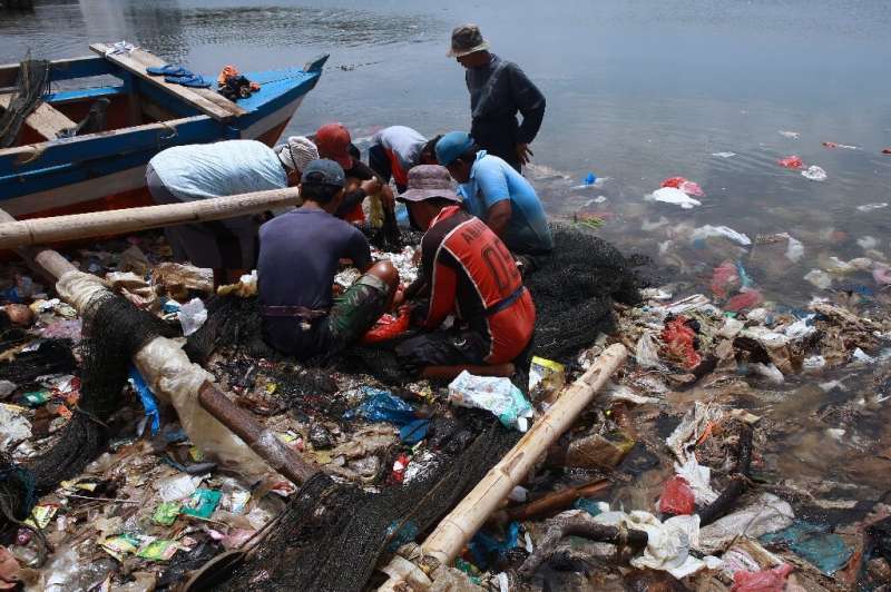 Fishermen sort catches from nets in plastic-contaminated waters in Bandar Lampung, Indonesia