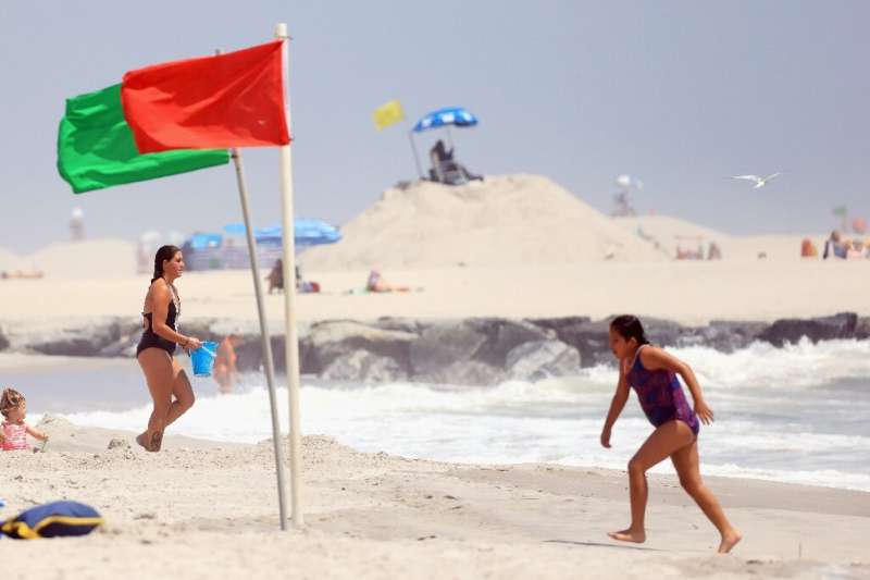 Flags direct swimmers to the safest areas on Long Beach in Long Beach, New York; beaches have been closed or restricted after a 