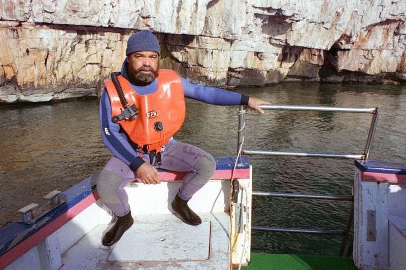 Henri Cosquer, the diver who found the cave, photographed on a boat above the entrance in 1991