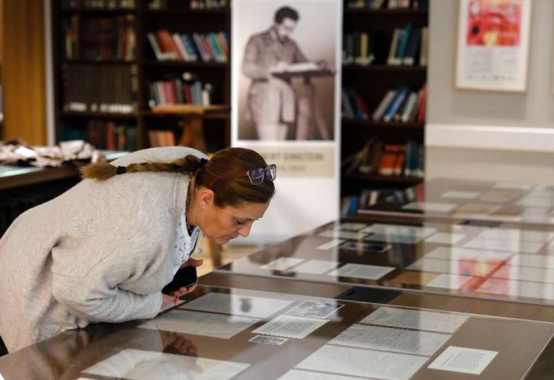 In this file photo from March 6, 2019, a woman checks Albert Einstein manuscripts at the Hebrew University in Jerusalem