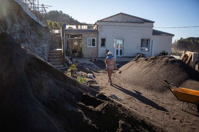 Maria Zobeida Perez Cabrera, 68, removes ash from her garden in the Las Manchas neighborhood of La Palma