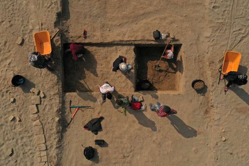 Members of a French-Iraqi archaeological expedition work on a dig at the site of the Sumerian city-state of Larsa, in southern I