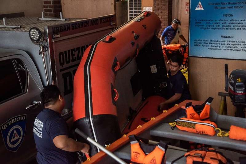 Сотрудники Управления по снижению риска бедствий и ликвидации их последствий готовят резиновые лодки и спасательные жилеты в преддверии супертайфуна Нору Мак