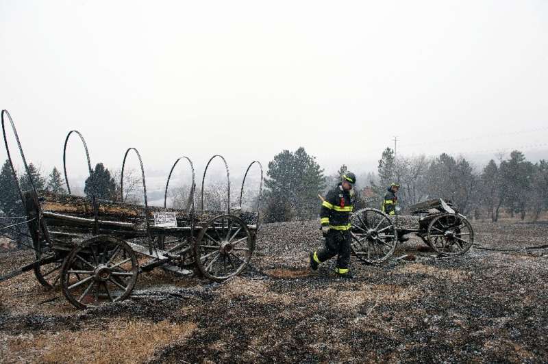 در 31 دسامبر 2021، آتش نشانان در حال قدم زدن در نزدیکی خانه ای بودند که توسط آتش سوزی جنگلی در شهرستان بولدر، کلرادو ویران شده بود.