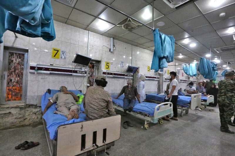 Patients suffering from breathing problems exacerbated by a heavy dust storm receive care at Sheikh Zayed Hospital in Iraq's cap