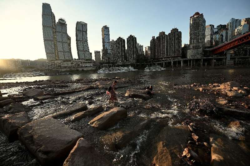 People are seen on the dried-up riverbed of the Jialing River in Chongqing