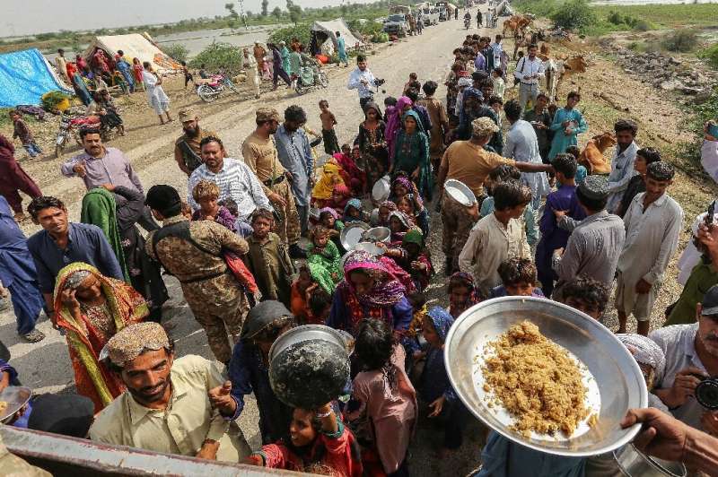 People displaced by the flooding queue for food near Ranpur